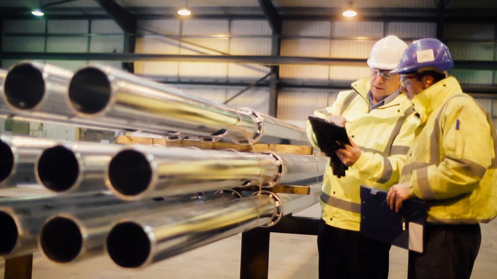 Celebrating long-time service. Joseph Ash employees inspecting galvanised pipes. 