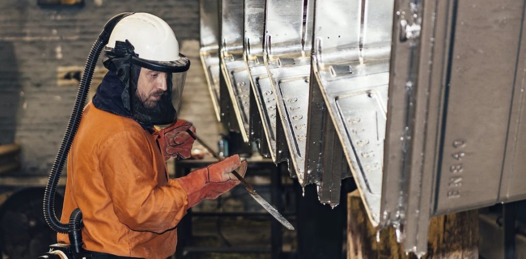 Team member fettling hot dip galvanized waste containers