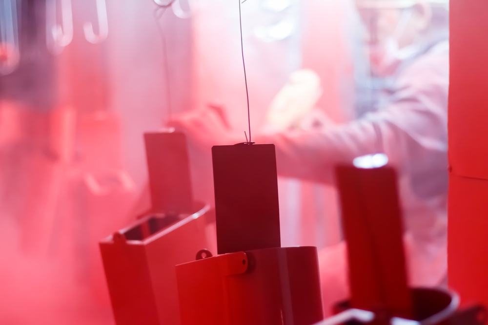 Steel being powder coated in a bright red colour
