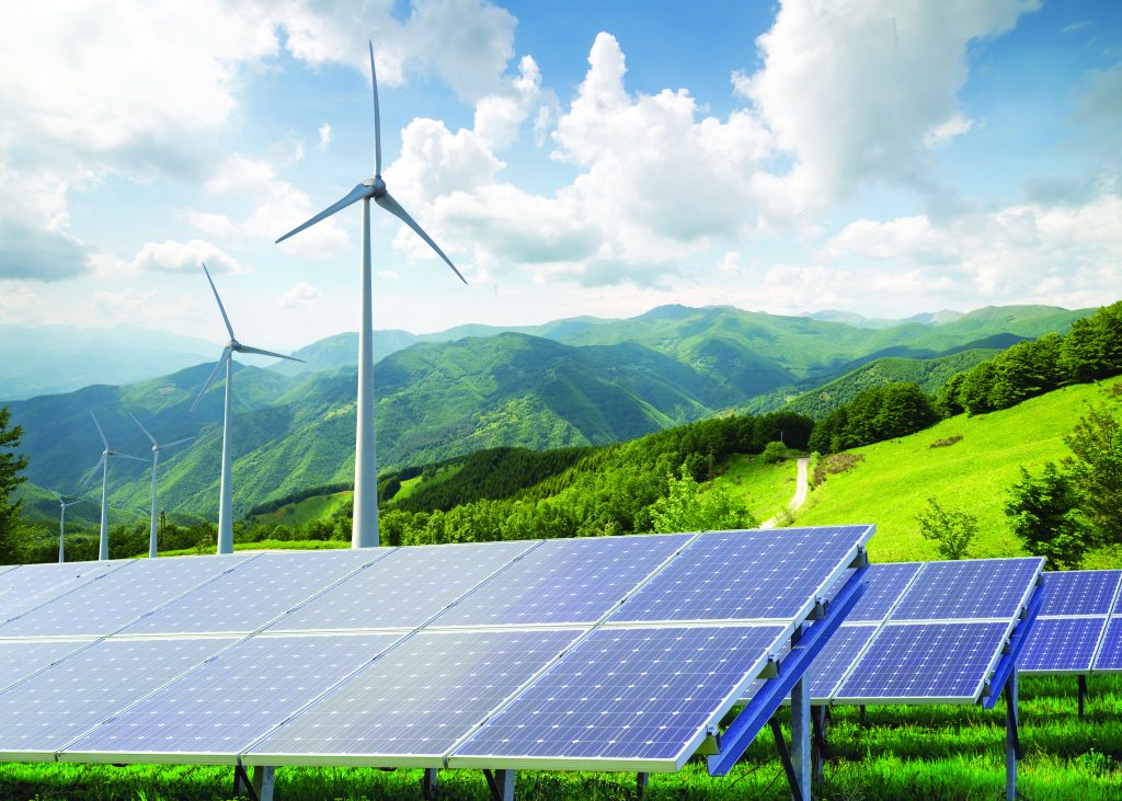 Wind turbines and solar panels in a grassy field